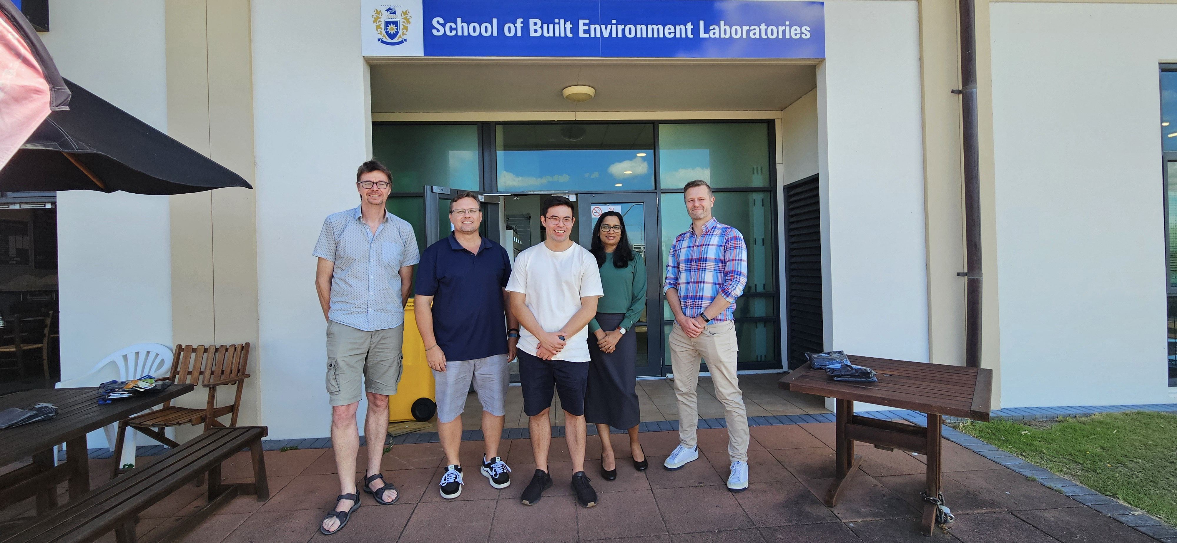 Group photo: Dr Mikael Boulic, Dr Hennie van Heerden, Robert Spencer, Dr Surangika Ranathunga, and A/Prof Teo Susnjak outside the School of Built Environment Laboratories at Massey University